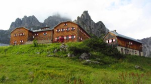 Die Hofpürglhütte vor der von Wolken umgebenen Bischofsmütze