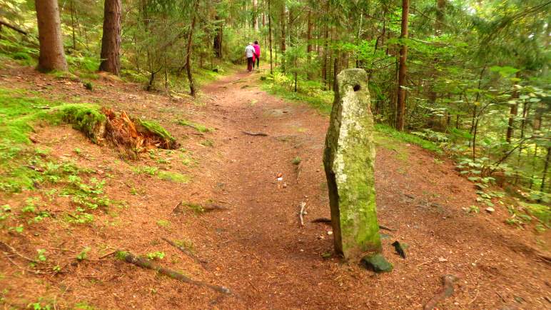 Ein Stein mit einem Loch, mitten auf dem Weg. Etwa hier ist der Abzweig ins Tal