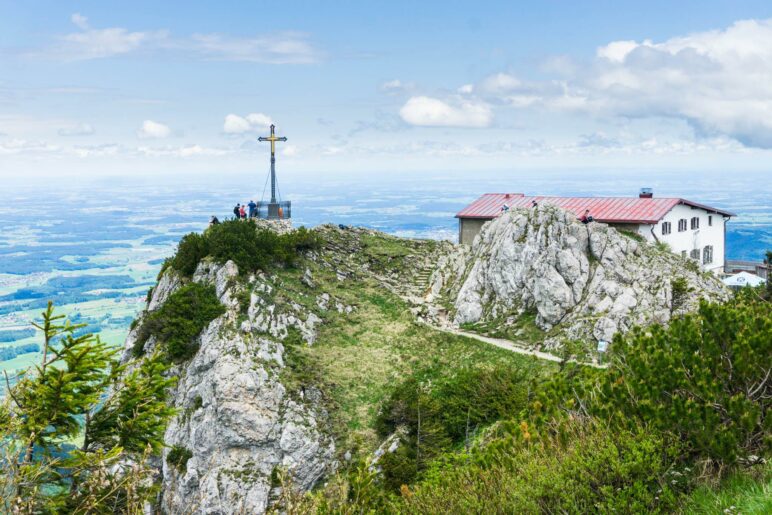 Das Gipfelkreuz des Hochfelln. Dahinter das Hochfellnhaus