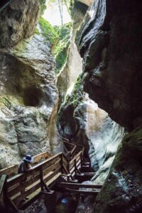 Weit oberhalb des Stegs scheint die Sonne in die schmale Schlucht