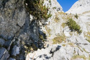 Unterhalb der Felswände führt der seilversicherte Weg bergauf